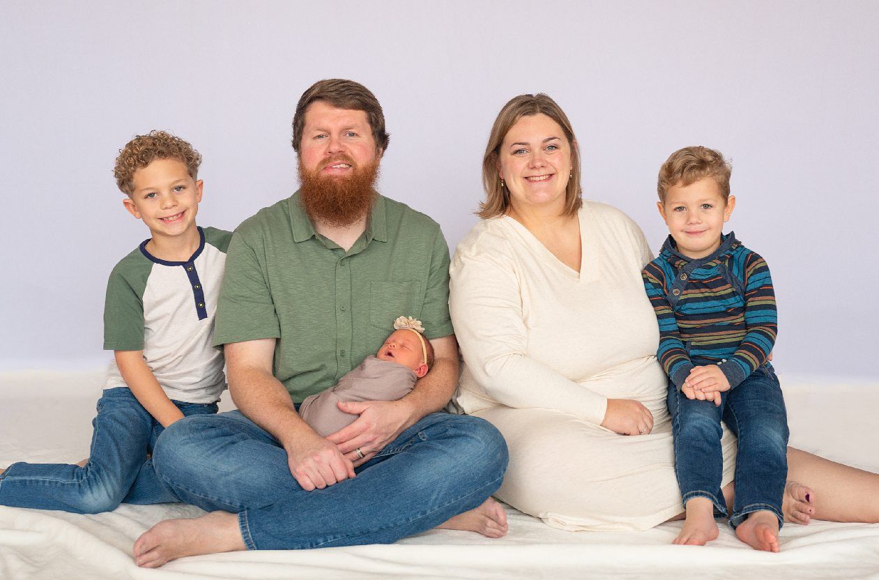 Newborn girl with family in natural light studio by Bartlesville Newborn Photographer Kristi Bray Photography