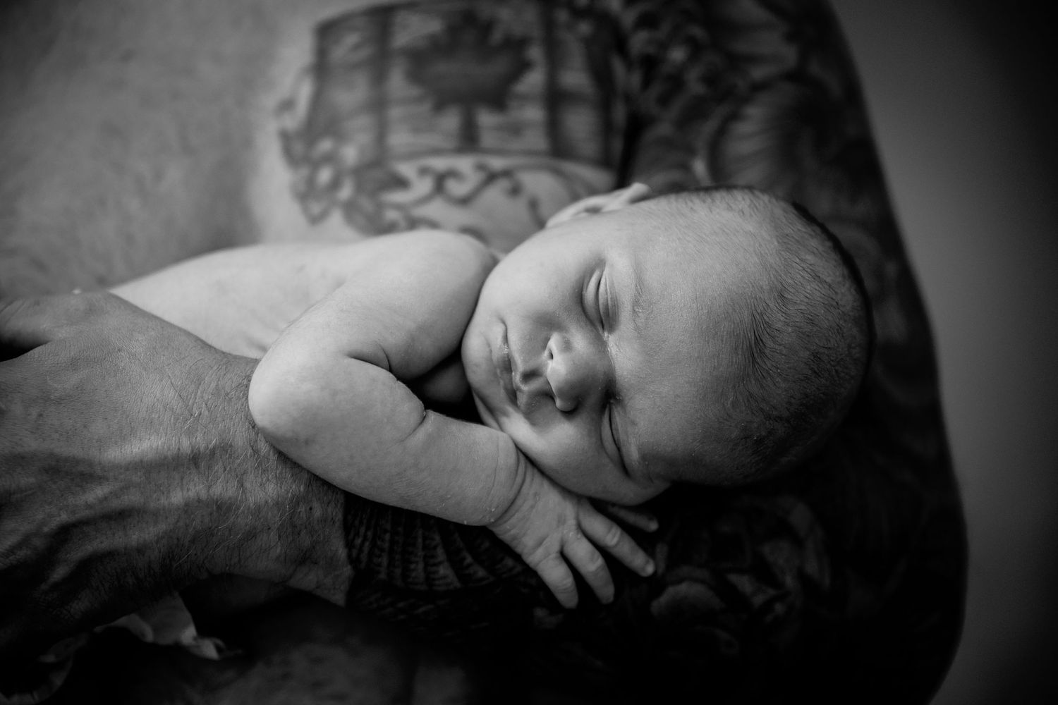 Sleeping newborn in black and white portrait.