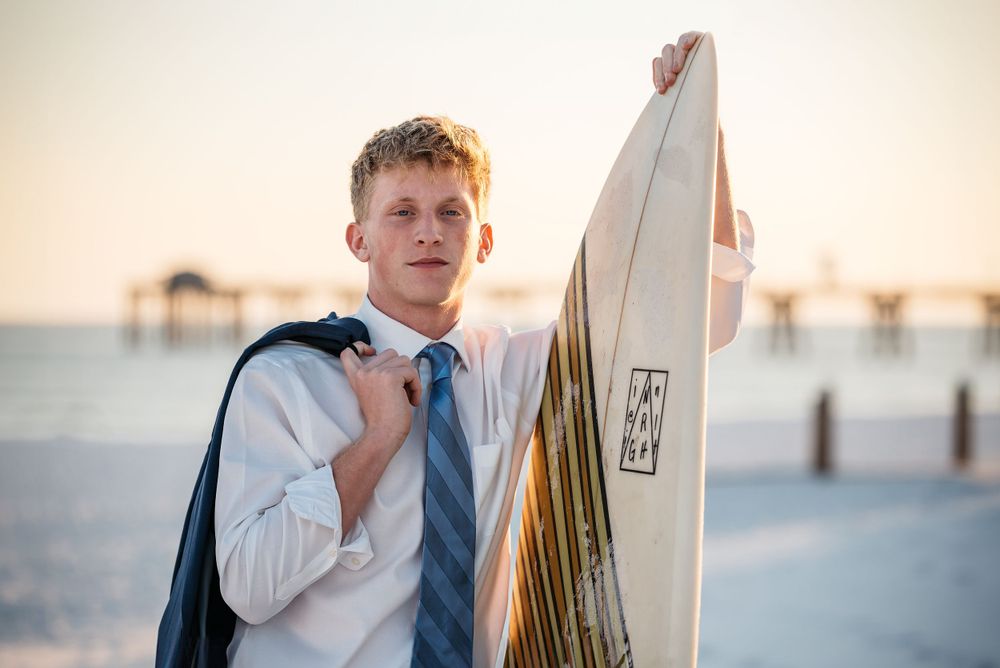 Fort Walton Beach Senior portraits lifestyle shoot at the boardwalk during sunset. Surfing photoshoot at the Boardwalk on Okaloosa Island FL