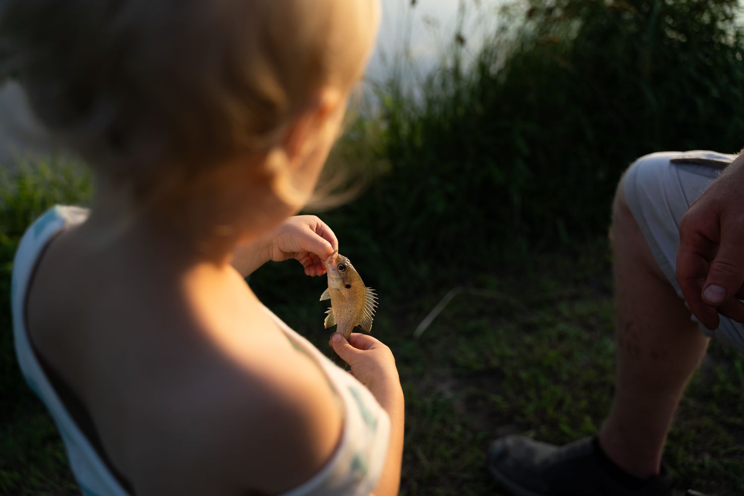 toddler holds onto first caught fish by Tulsa family photographer