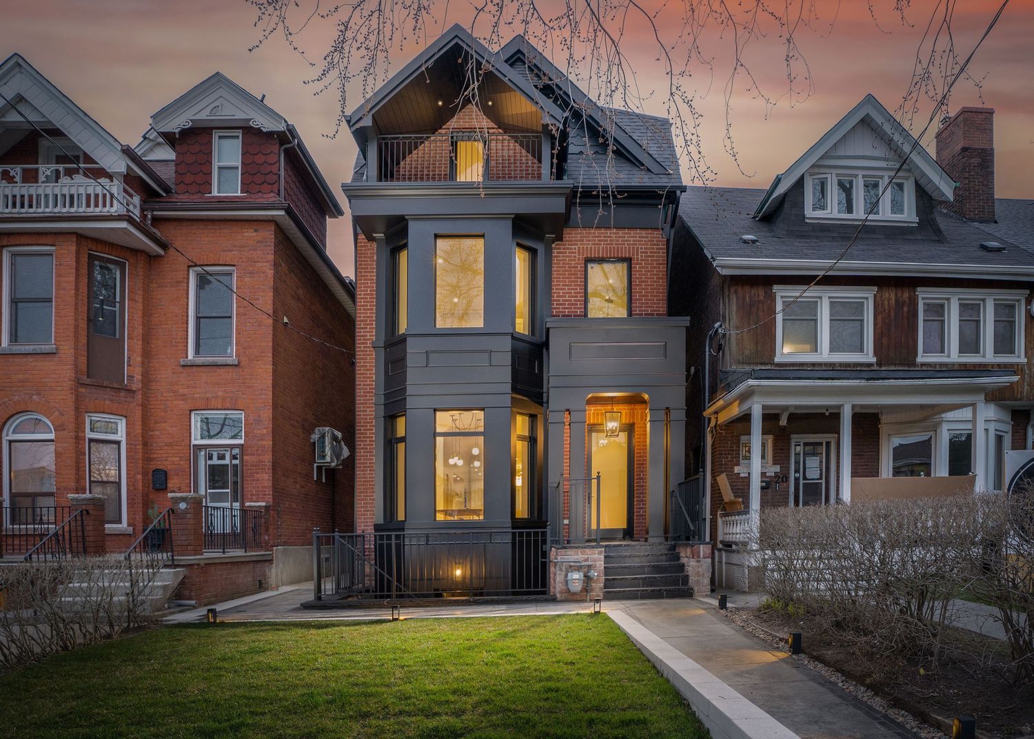 22 Shannon St, Toronto. Rows of historic Victorian houses at sunset with warm glowing windows.