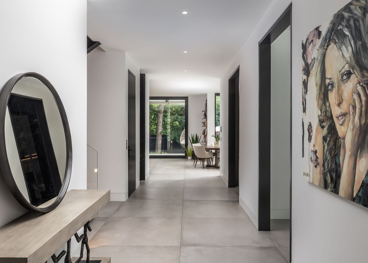Long white hallway with modern art displays and recessed lighting.