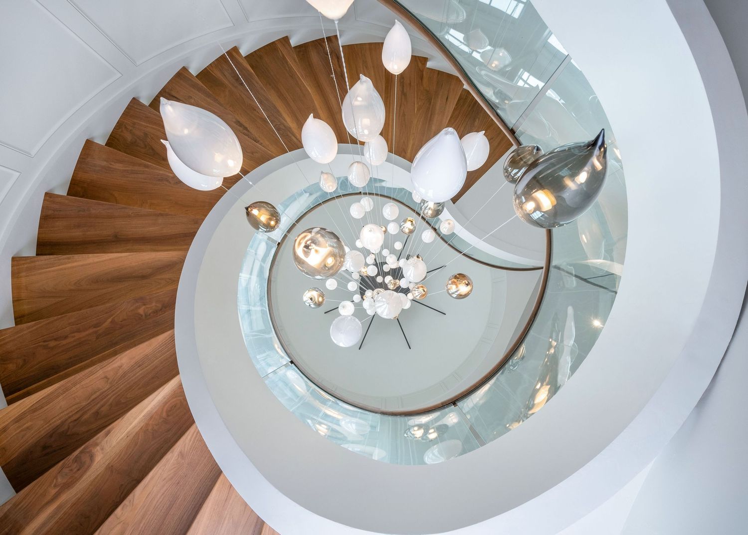 Circular ceiling detail with modern crystal chandelier and wood flooring in a luxury King City, ON. mansion.