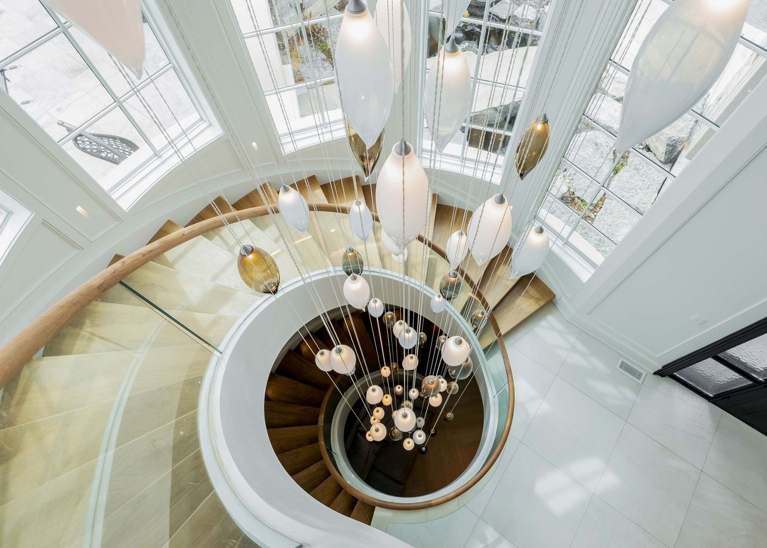 A modern spiral staircase of a luxury home in King City, ON built by Belairbiuld.