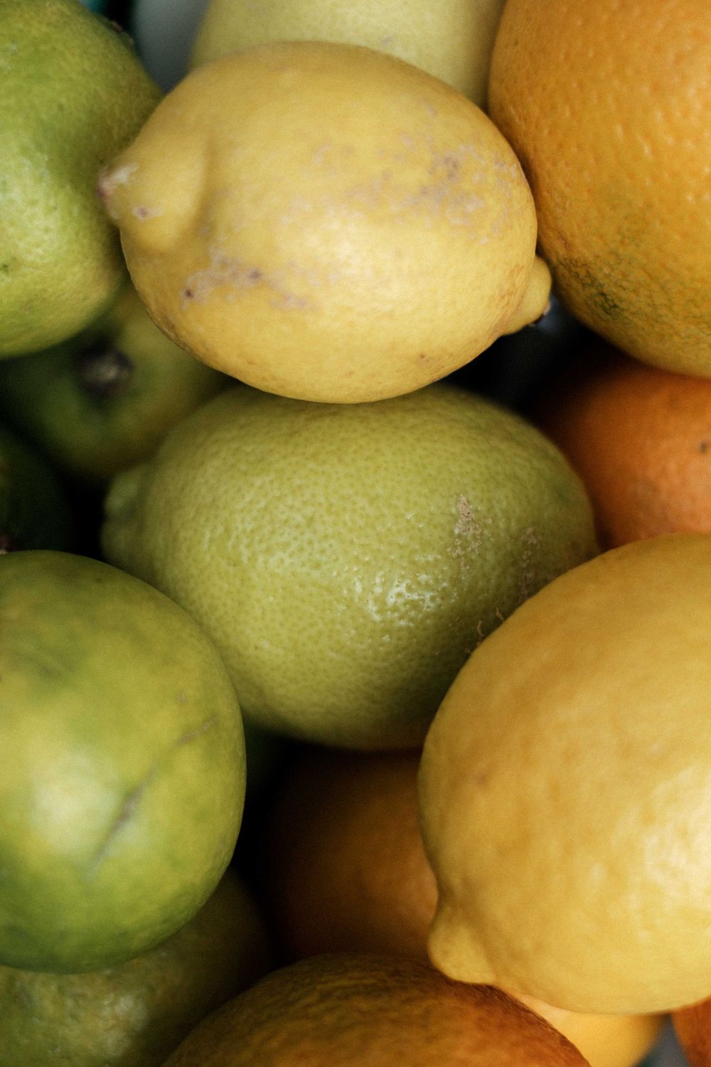 Fresh citrus fruits including yellow lemons and green limes clustered together in a close-up shot.
