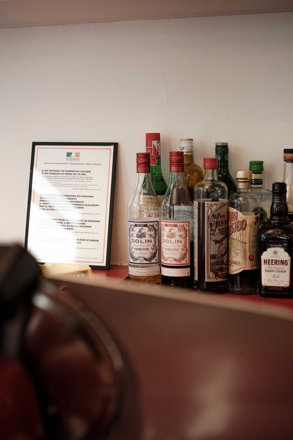 Collection of vintage liquor bottles and a framed certificate displayed on a shelf.