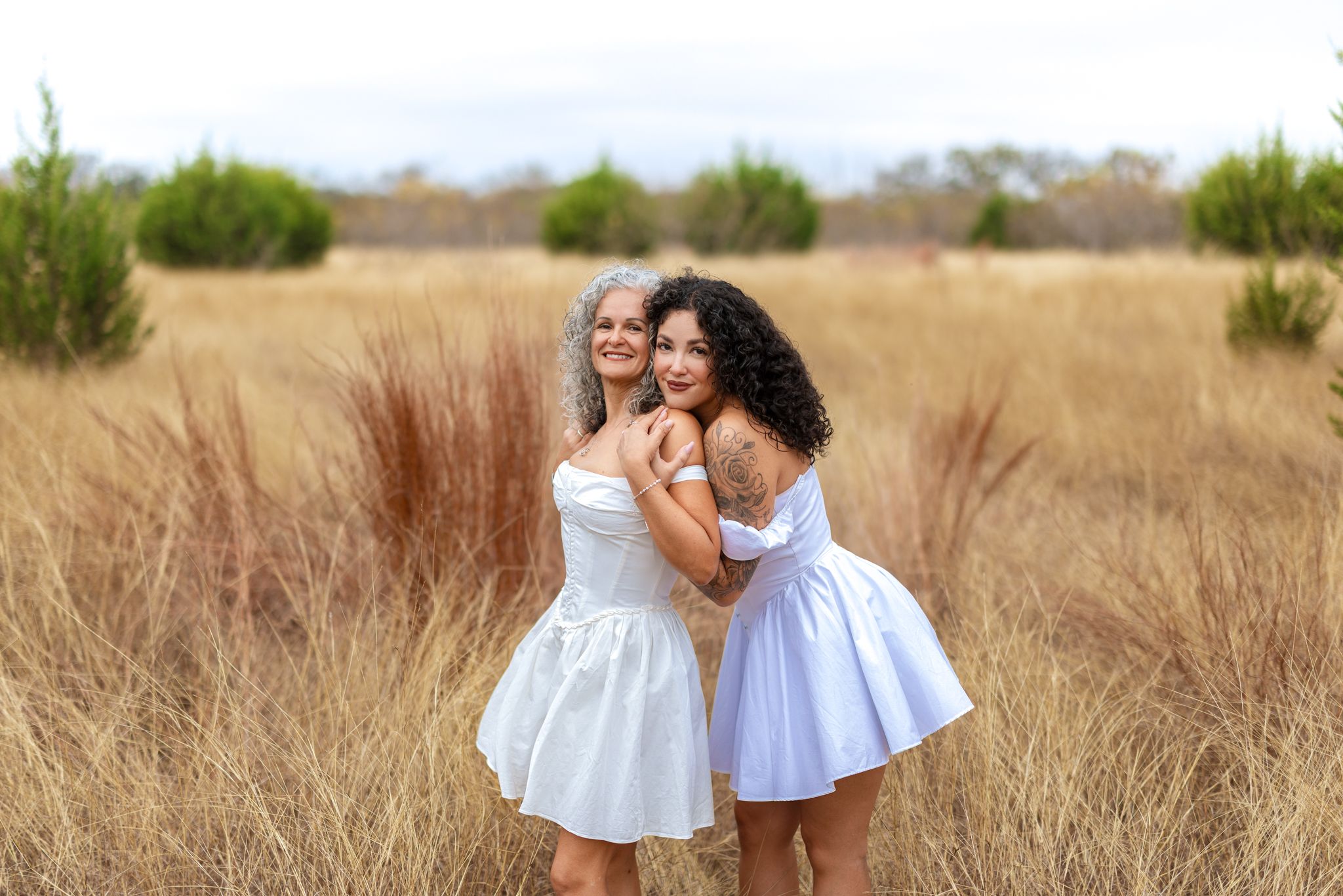 Two people share an intimate moment in a golden wheat field at sunset.