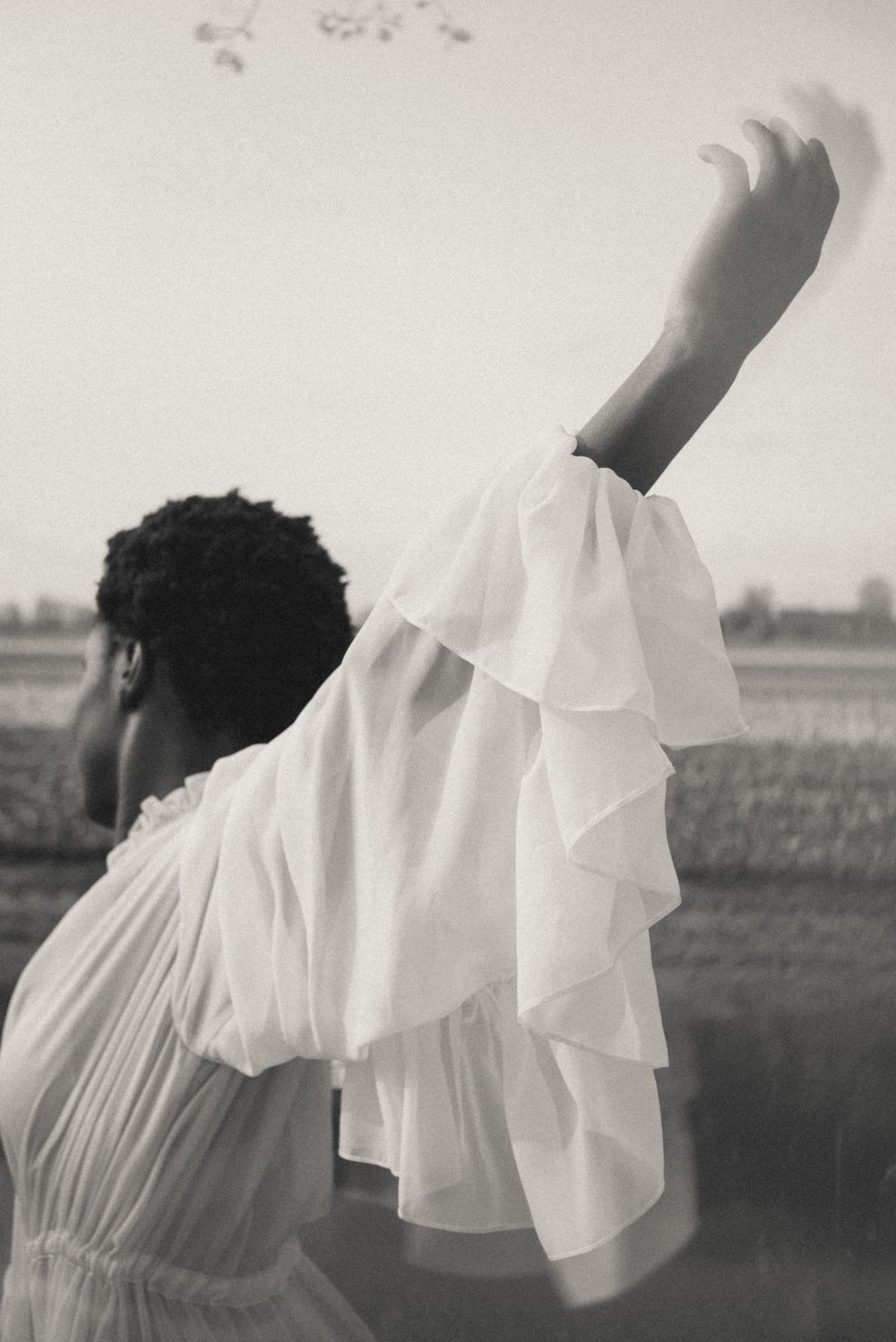 Artistic black and white photos showing flowing white fabric sleeves against a minimal background.