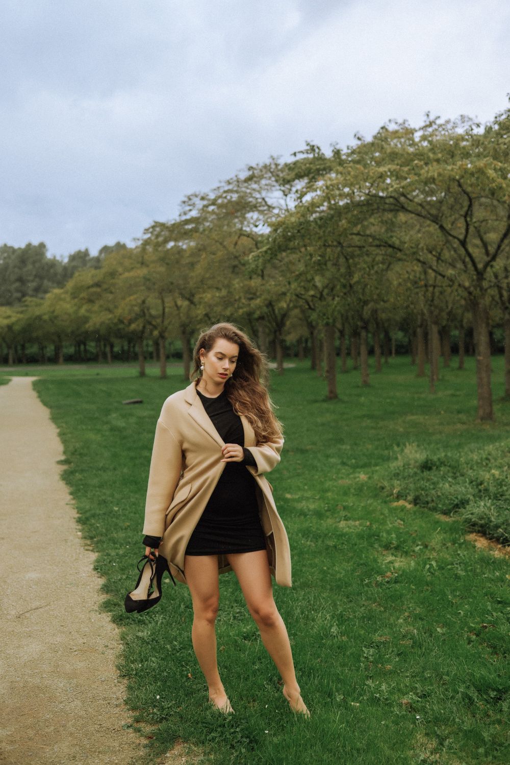 A stylish autumn outfit captured on a path through a serene park setting.