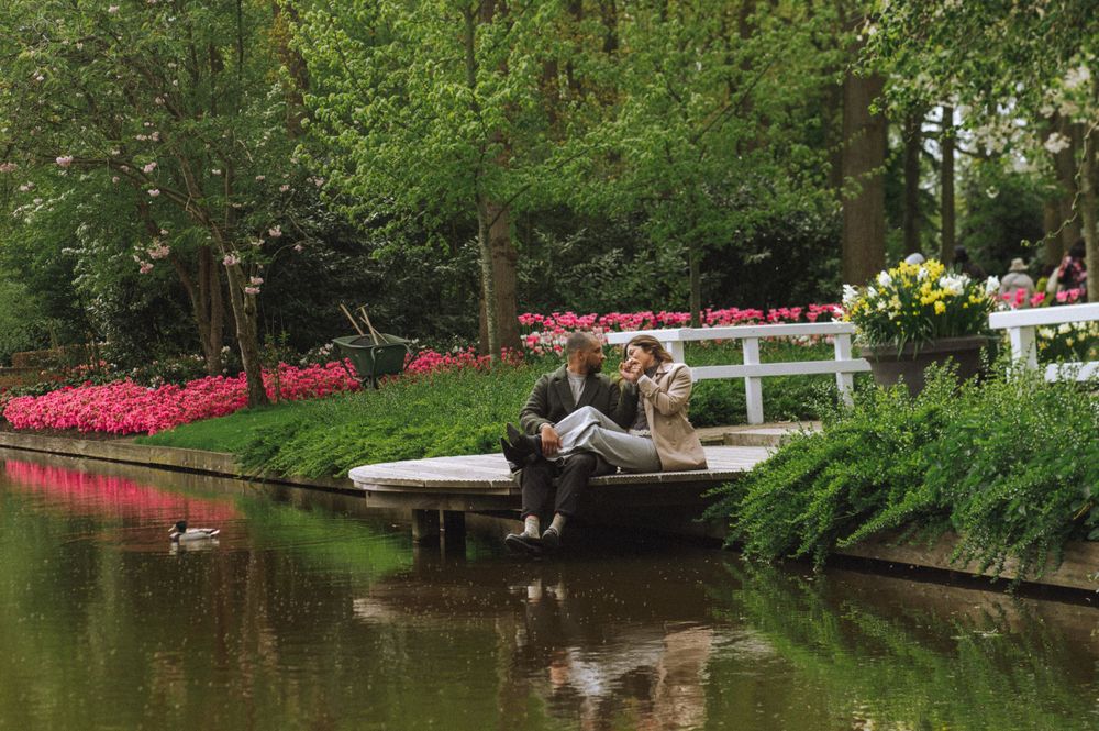 Scenic view of a tranquil pond surrounded by blooming spring flowers and trees.