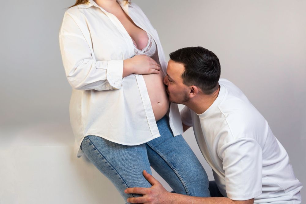 Séance photo minimaliste en studio d'une femme enceinte, capturant la douceur et la sérénité de la grossesse dans un cadre simple et épuré.