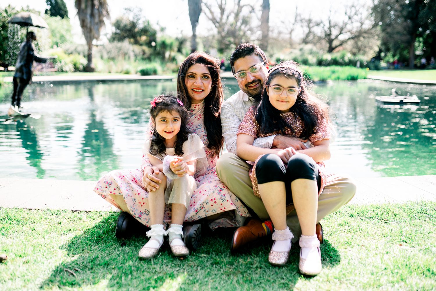 A happy family of 4 in Melbourne's St Kilda Botanical Gardens with lush greeneries as backdrop taken by a Melbourne family photographer.