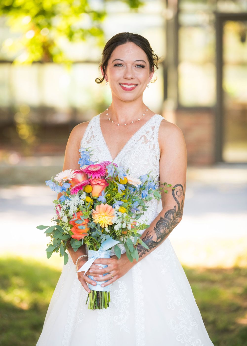 Close-up shots of vibrant coral and orange wedding bouquets with greenery against a bright outdoor background.