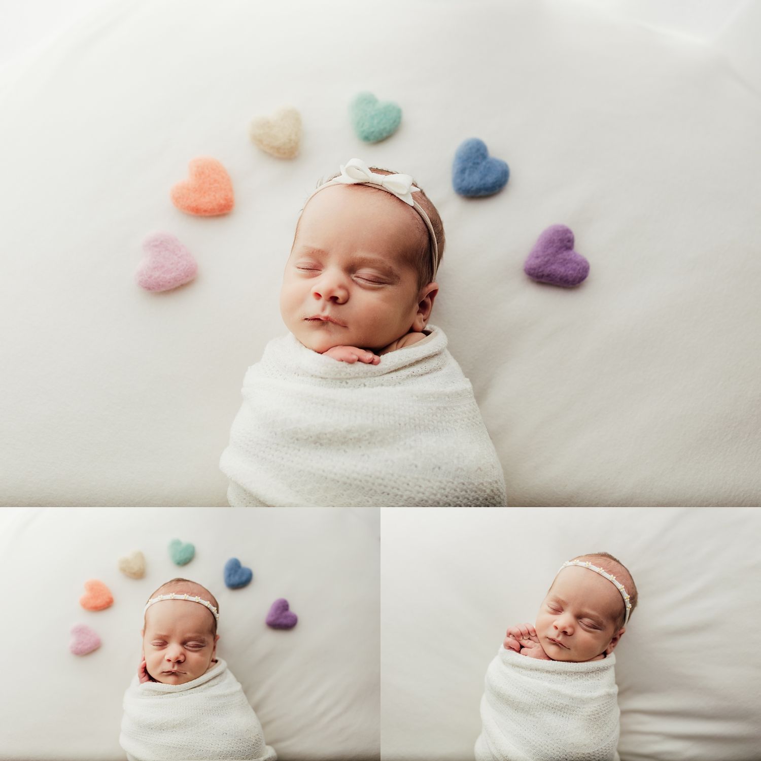 Sleeping newborn baby swaddled in white wrap with colorful felt hearts arranged in arc, wearing bow headband.