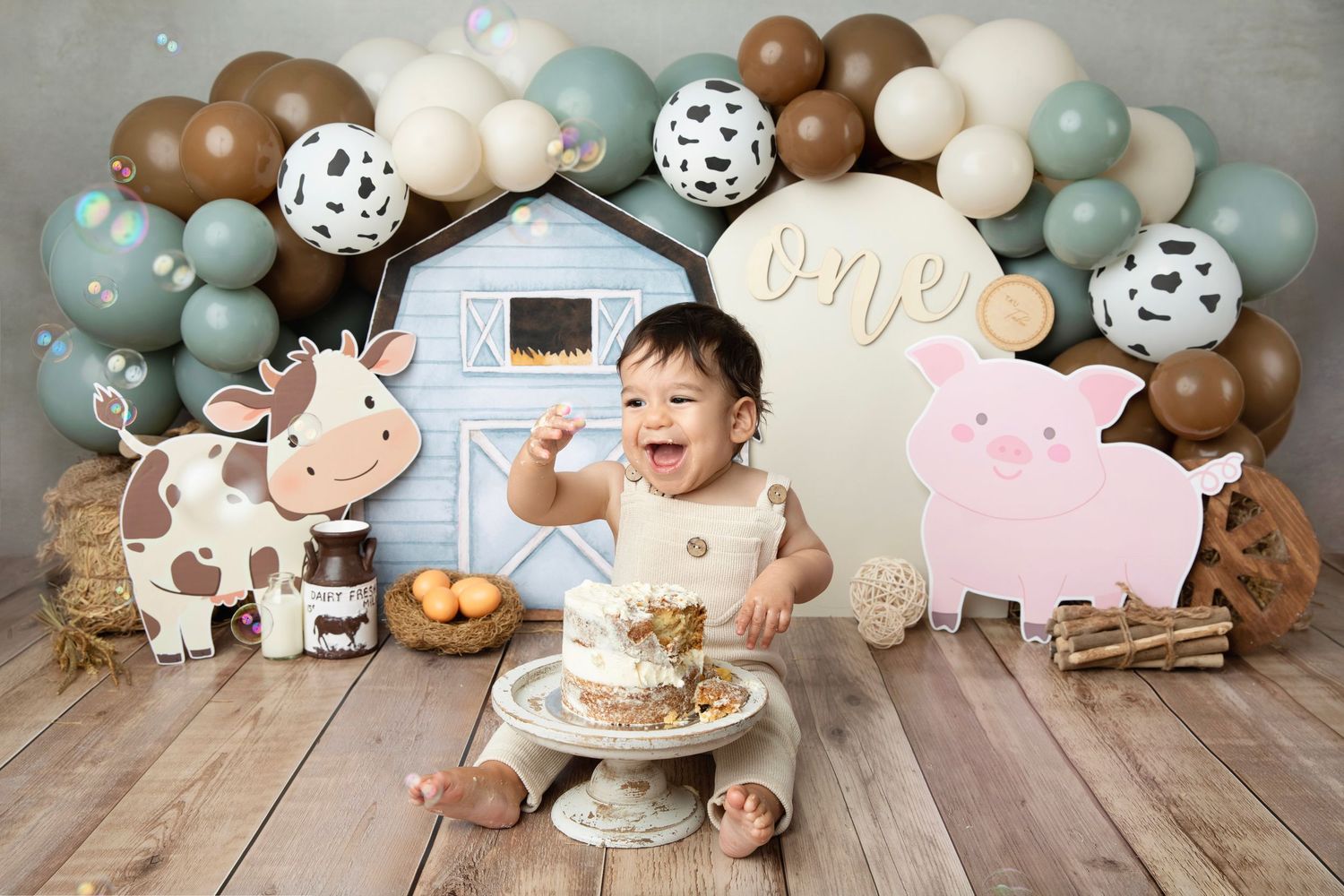 Baby girl in mermaid outfit celebrates first birthday with cake smash in underwater themed photo session.