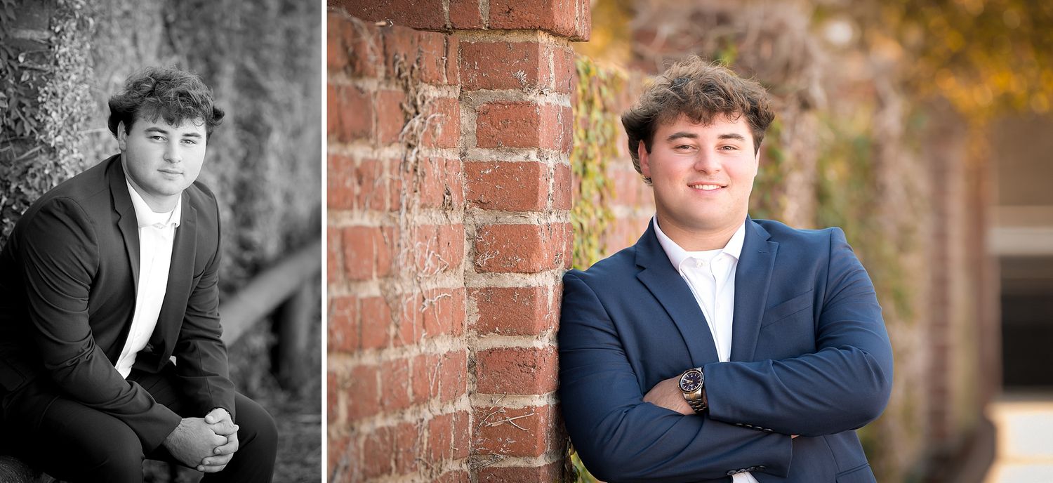 Young man in a navy blazer poses confidently against a brick wall in a professional senior portrait photo session.