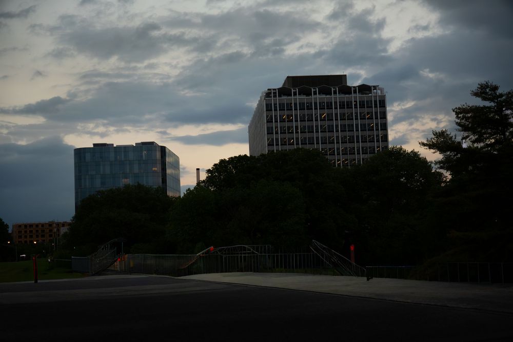 Dark silhouette of urban buildings against a dramatic cloudy sky at twilight.