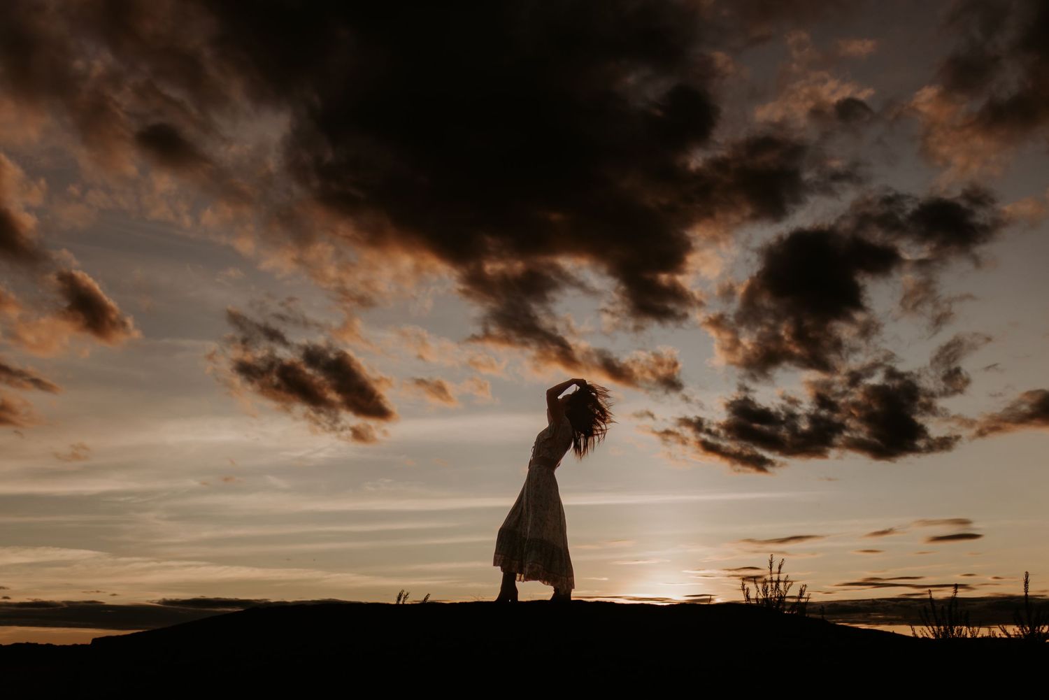 Christina standing in front of sunset as a silhouette at the Granite Mines in Mount Isa