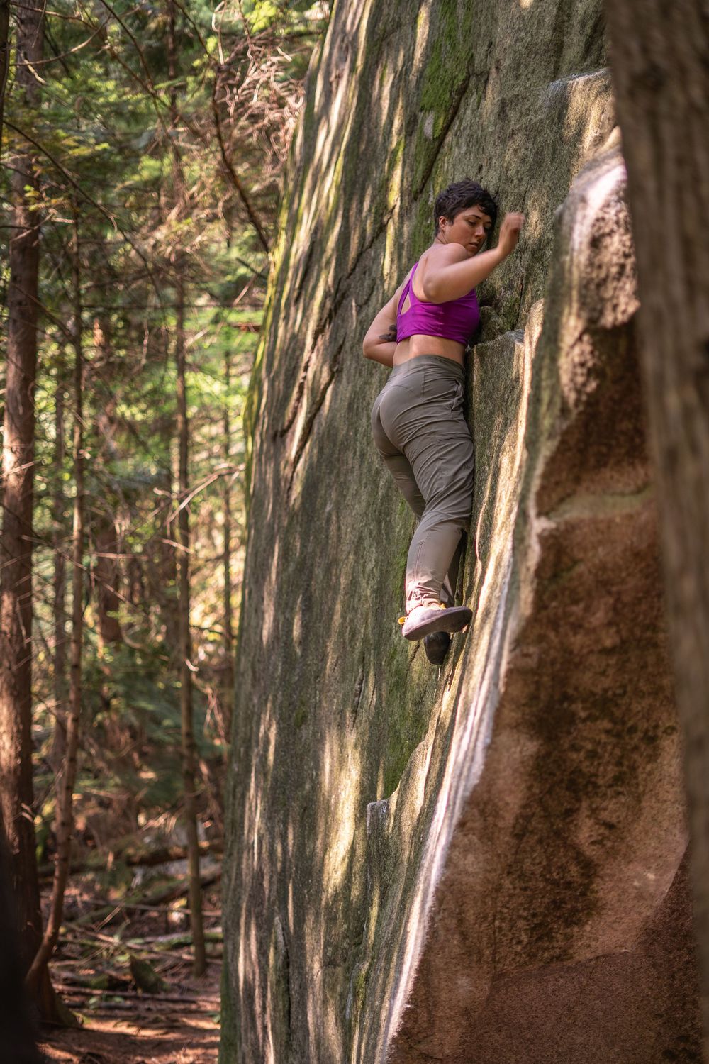A woman boulders in the forest near Squamish, BC