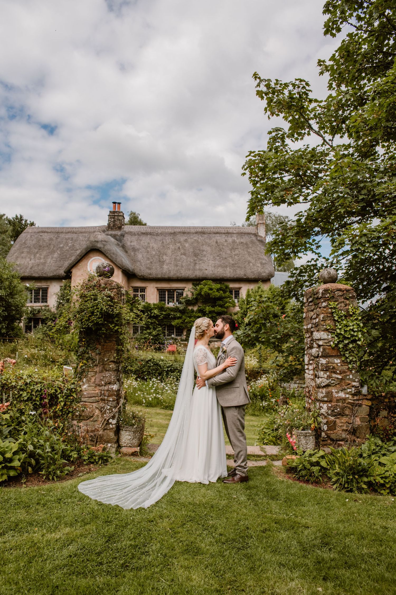 Bride and groom share their first dance in an elegant ballroom with arched windows and floral decor at their wedding reception.