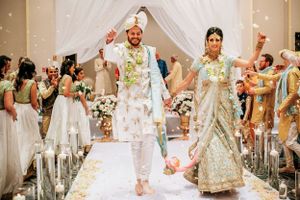 Wedding celebration with guests dancing and enjoying festivities in a decorated white venue.