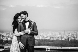 Romantic black and white wedding portraits captured against city skyline.