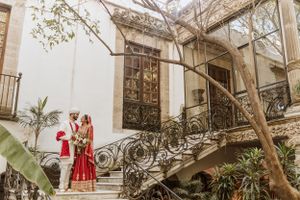 Architectural wedding venue with white walls and natural greenery.