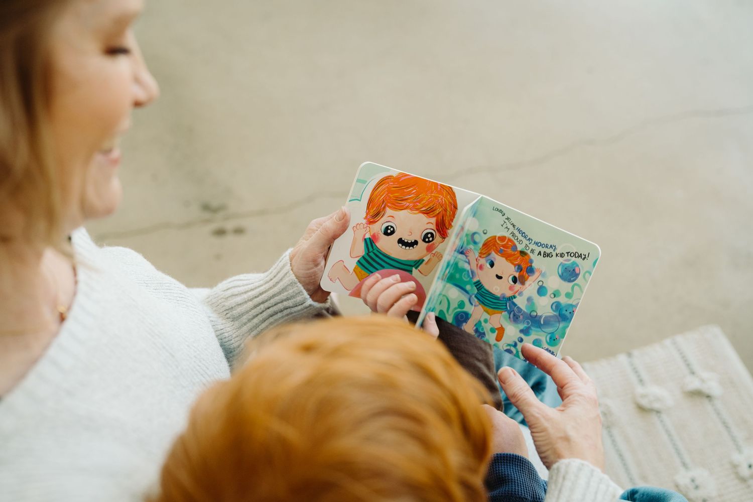 Angie and her son reading the Wizzy Fizzies book together during a brand photography session