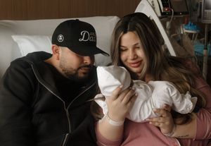 New parents share a tender moment with their newborn baby in a hospital room after delivery.