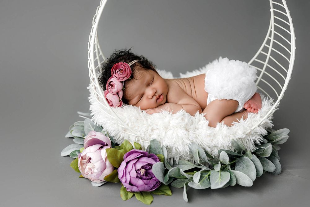 Sleeping newborn baby girl in white outfit by Perris newborn photographer.