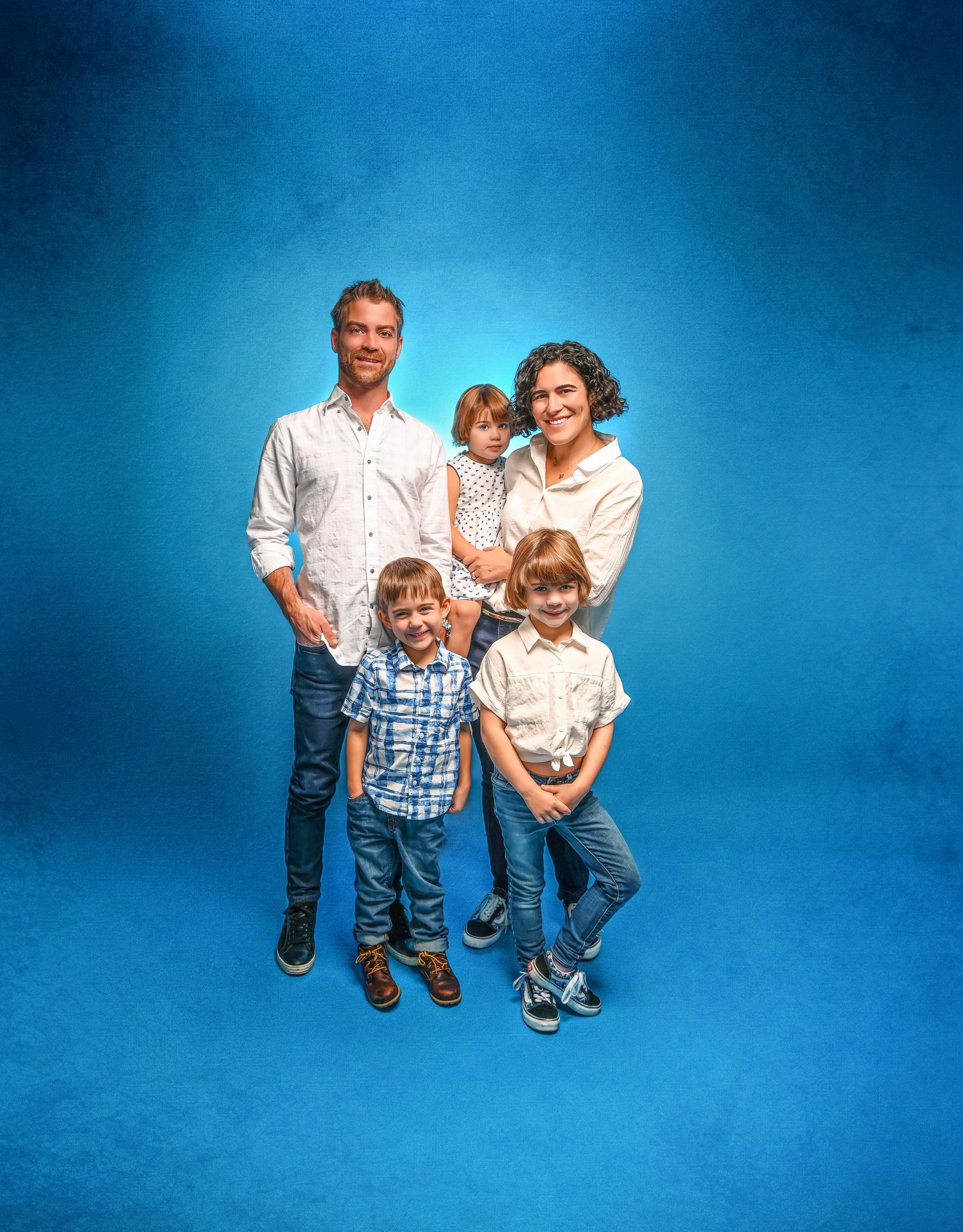 A family portrait series against a gray backdrop showing joyful interactions and coordinated formal attire.