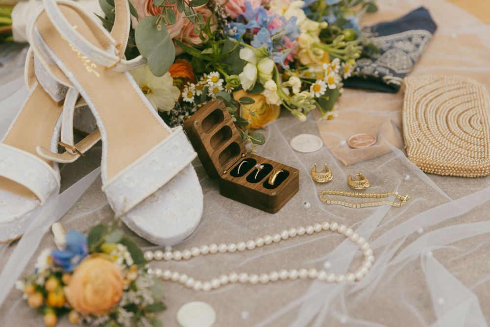 Wedding detail flatlay with pearls, flowers and delicate decor items.