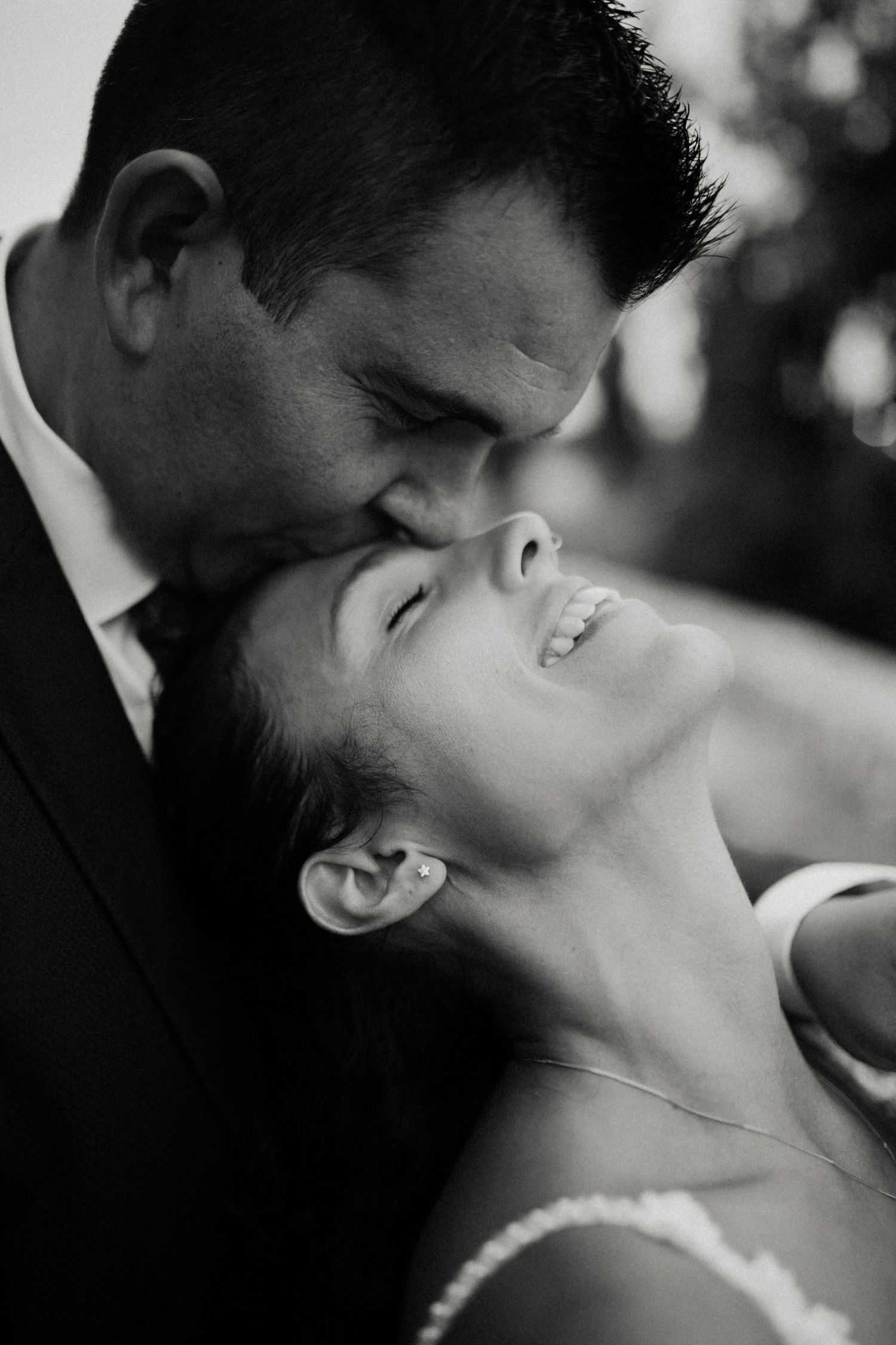 Novio besando la frente de la novia en fotografía de boda en blanco y negro en Tarragona