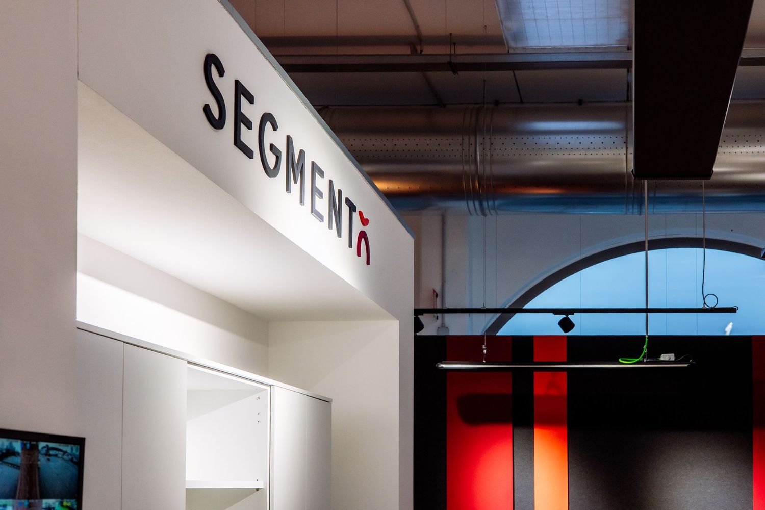 Interior signage showing the word 'SEGMENTA' mounted on a white wall with modern architectural details.