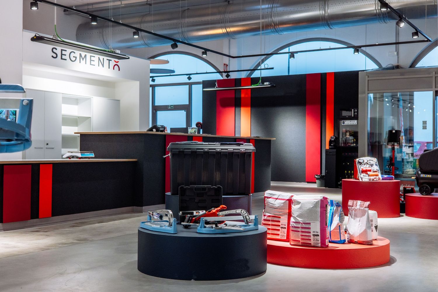 Modern office interior with red and black color scheme featuring sleek architectural elements and curved walls.