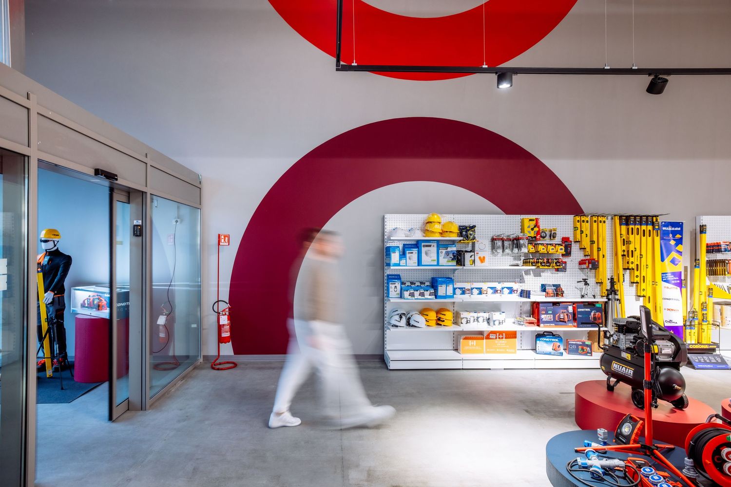 Modern office interior with red circular wall features and sleek minimalist design elements in an open workspace.
