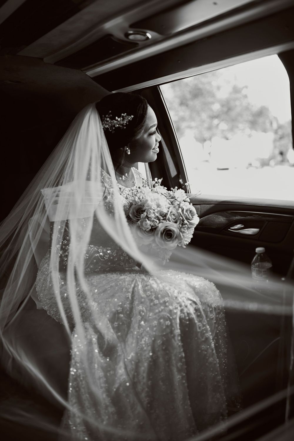 A black and white sequence of photos showing a bride in a flowing veil sitting in a car on her wedding day.