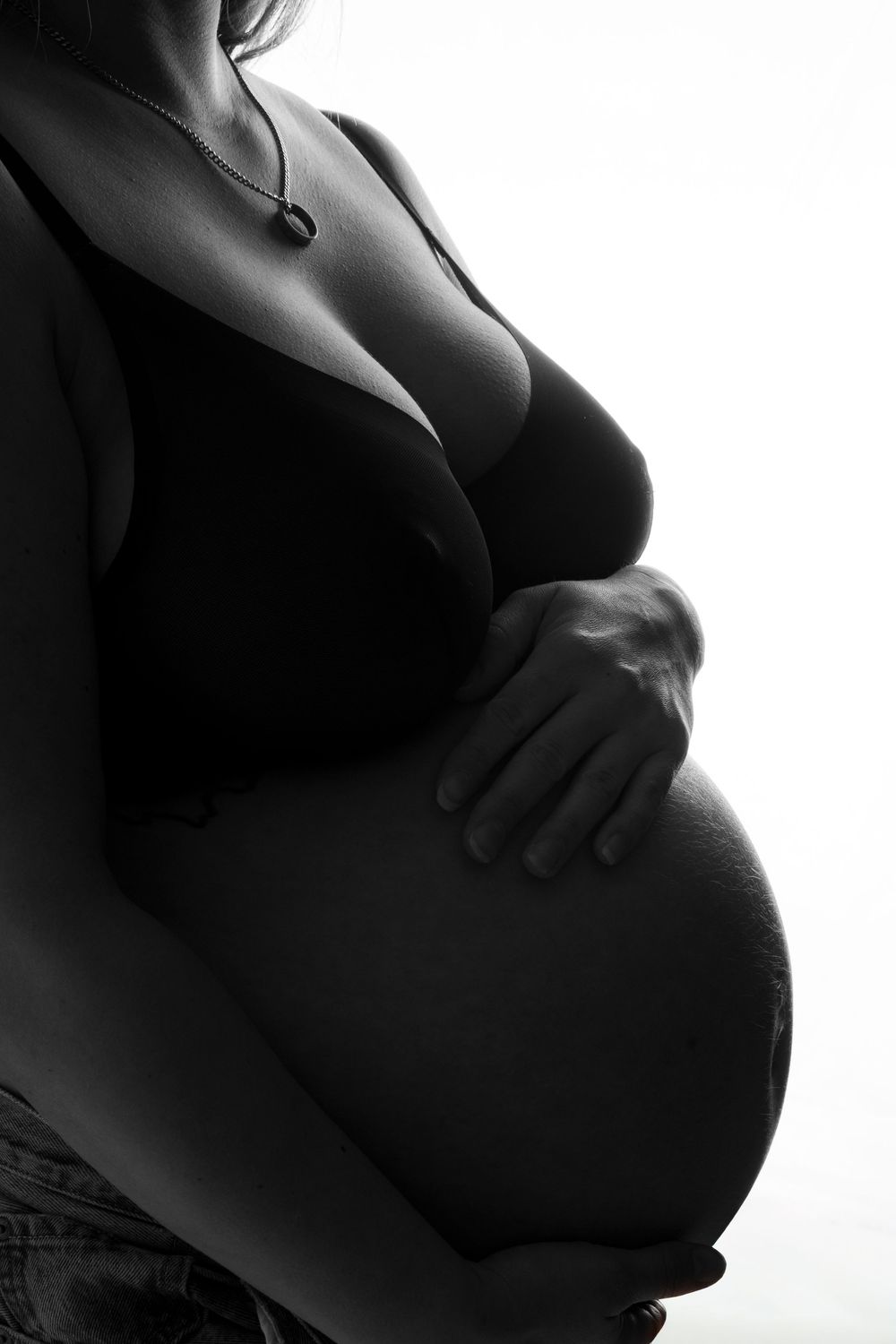 Black and white silhouette photographs showing the profile of a pregnant belly against white background.