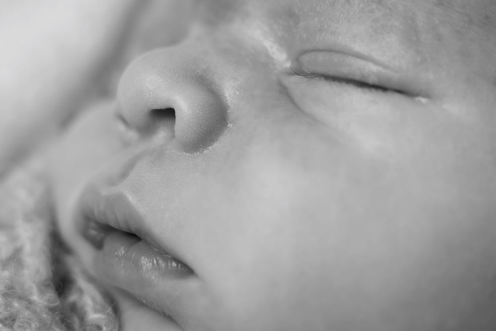 A series of black and white close-up photos showing different facial features and expressions in soft lighting.