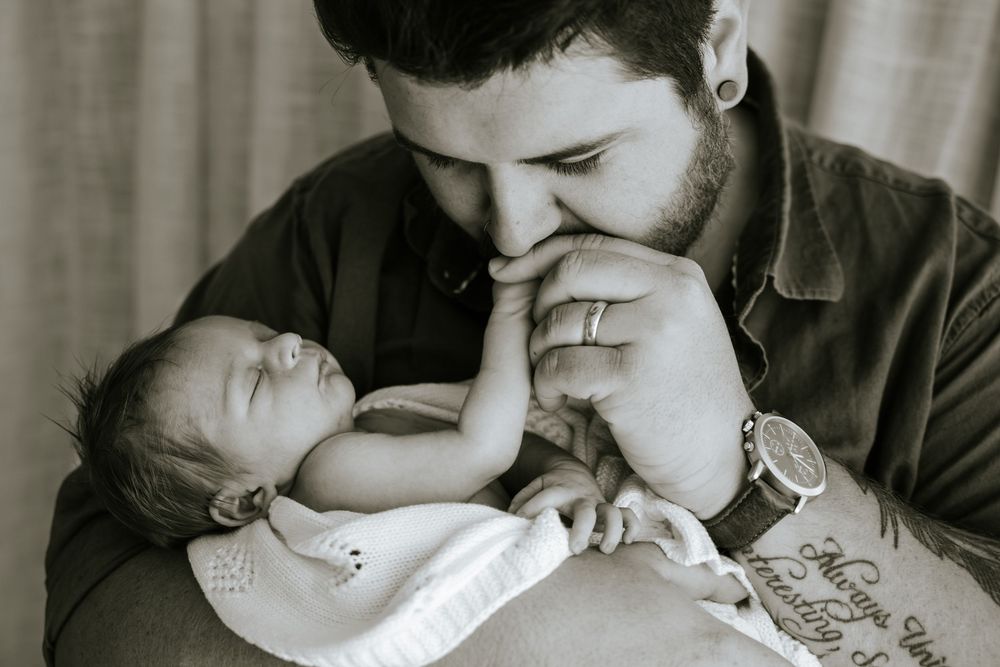 A tender black and white moment between parent and infant as they share a quiet connection.