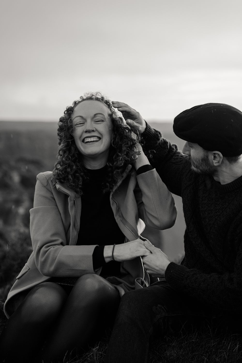Couple laughing together while walking along Doolin Cliff Walk during cinematic sunset session