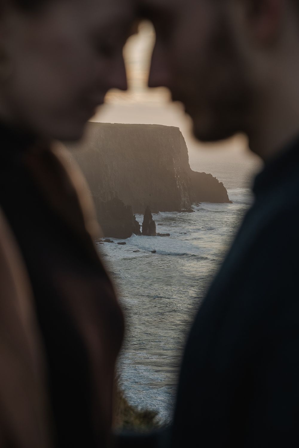 Romantic moment between couple watching sunset over the Cliffs of Moher