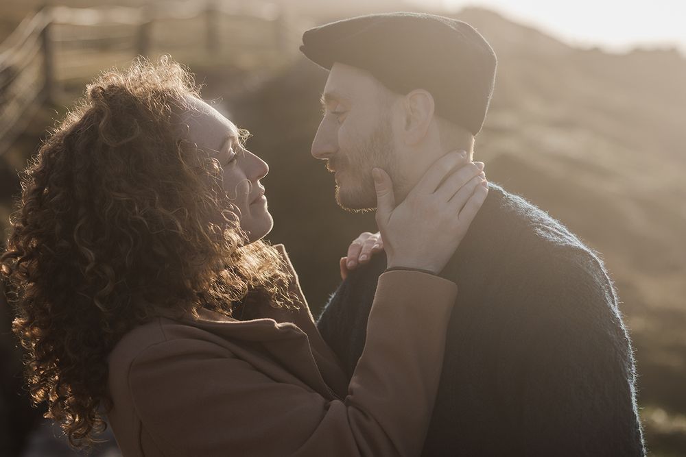 Romantic moment between couple watching sunset over the Atlantic Ocean at Cliffs of Moher