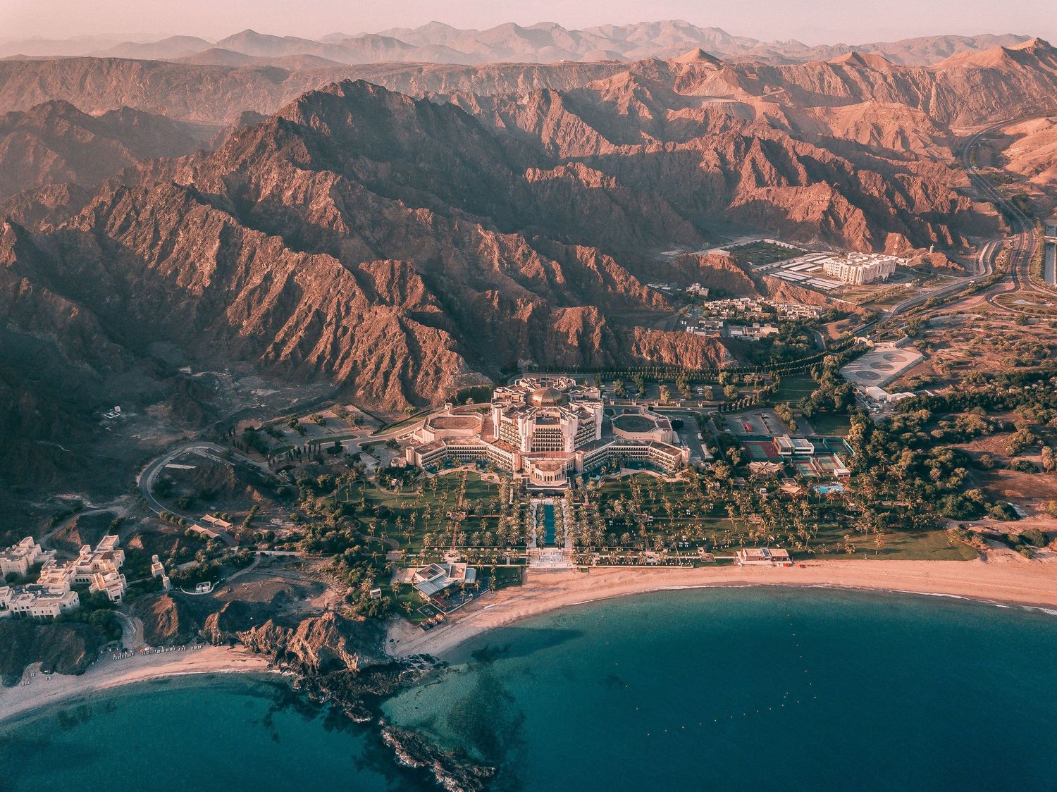 Aerial view of Pepperdine University campus nestled along the Malibu coastline with rugged mountains in the background.