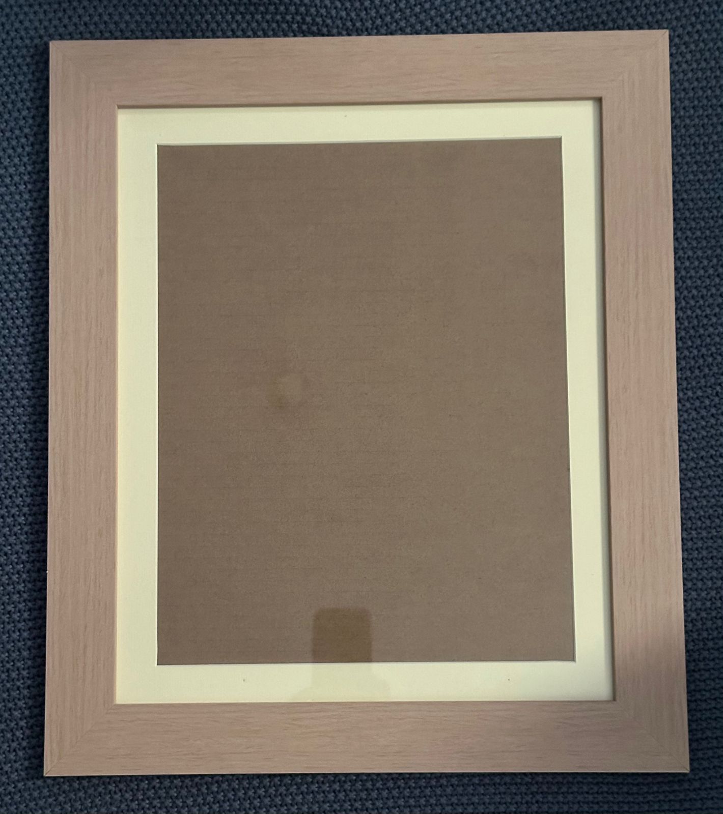 Multiple beige and brown picture frames arranged horizontally against a navy blue background.