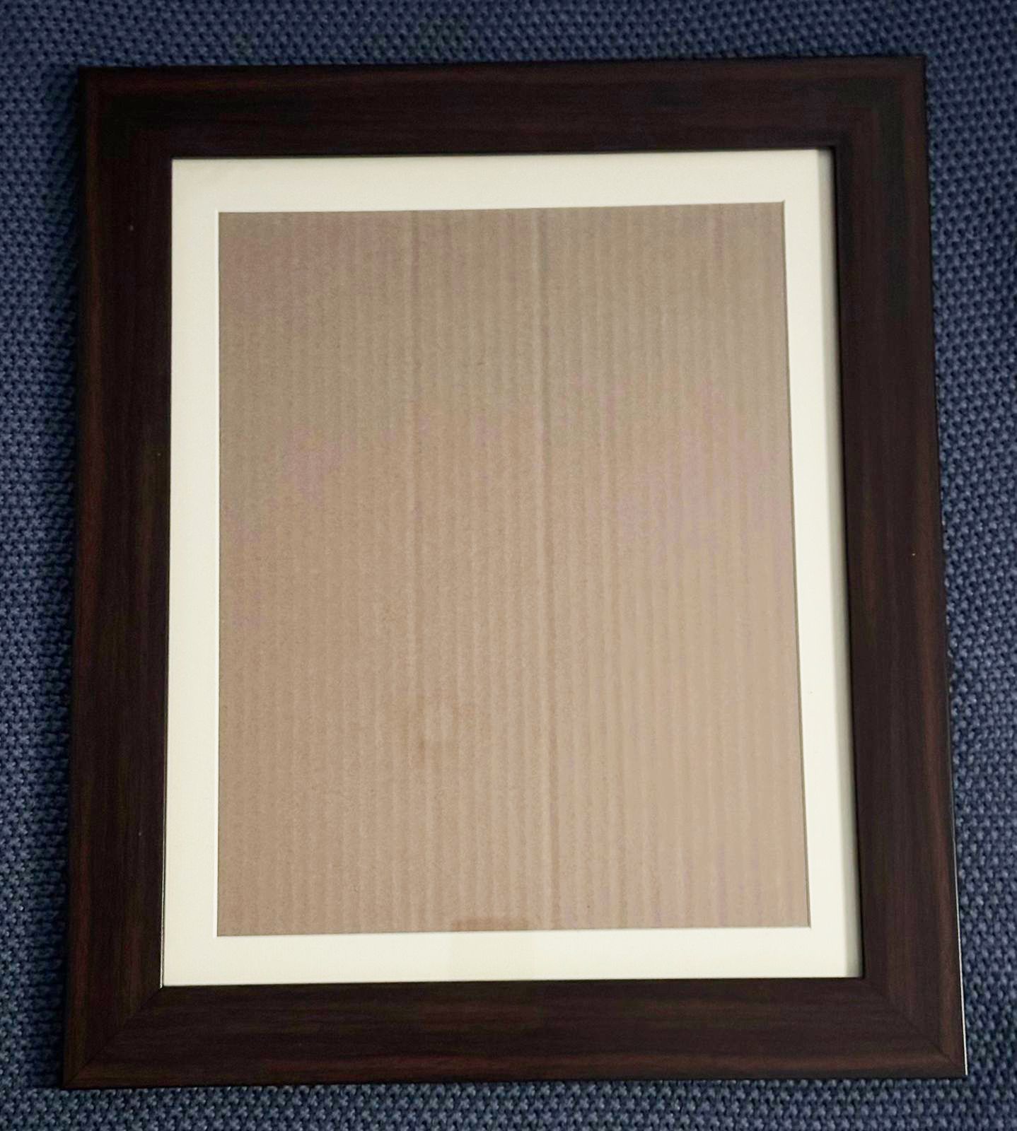 Row of dark brown wooden picture frames hanging on a textured blue wall.