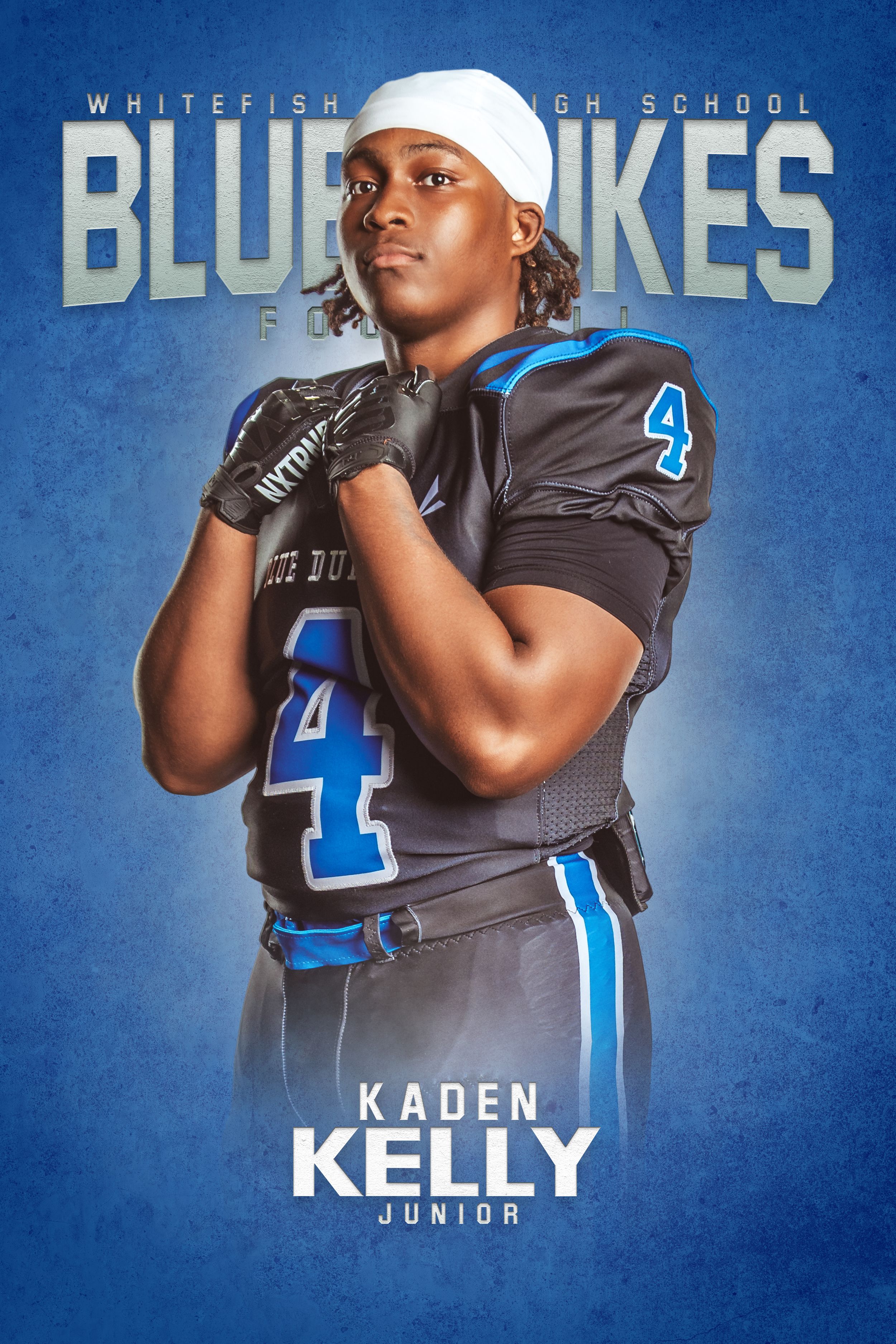 High school football player poses in blue and gray uniform with number 4 against blue background.