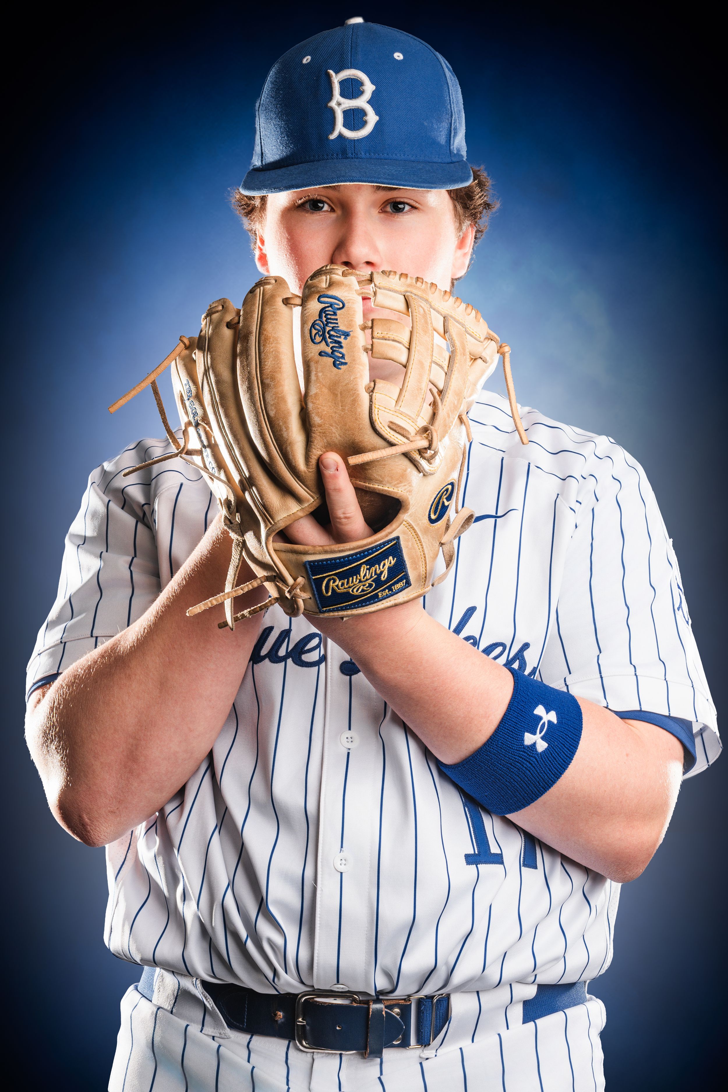 Baseball player in Brooklyn Dodgers pinstripe uniform demonstrates various pitching grips against dark background.