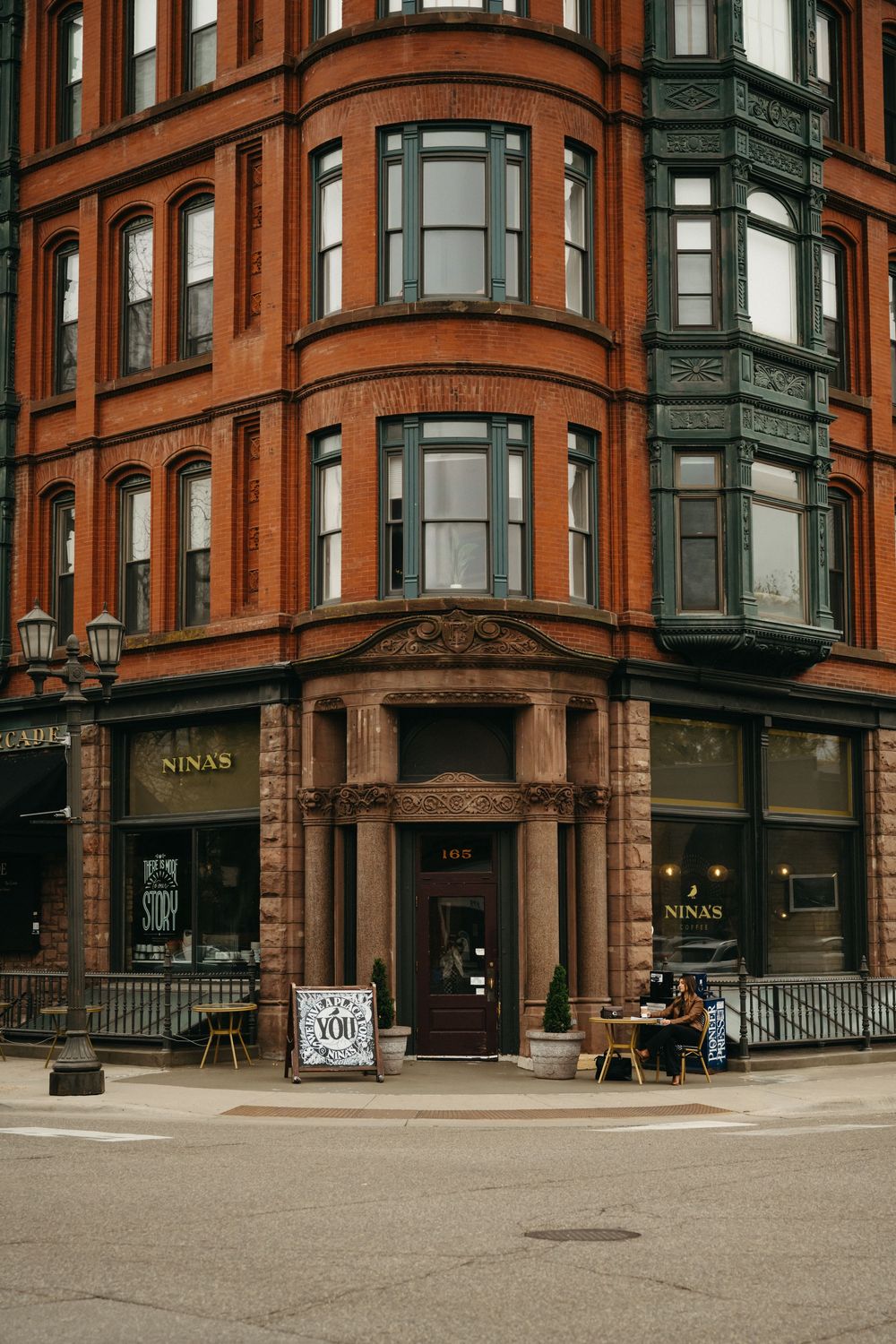 Exterior view of a historic red brick building with ornate Victorian architecture and large windows.