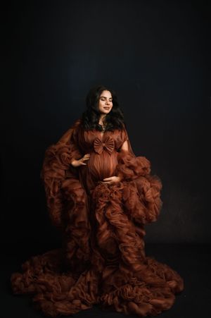 A dramatic fashion photo series featuring a flowing brown ruffled gown against a dark background.